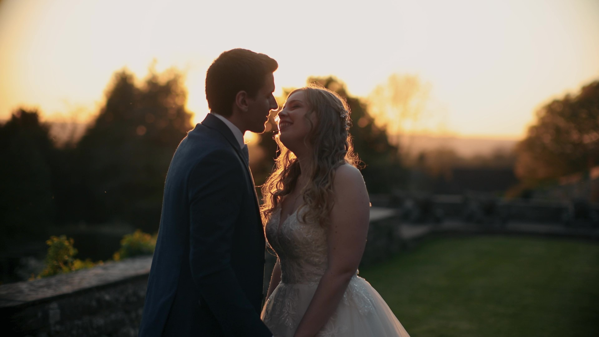 Romantic cinematic wedding film moment with couple embracing at sunset